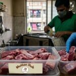 Fresh raw mutton pieces hygienically packed in food-grade containers for same-day home delivery in Kolkata, with a delivery executive preparing orders in a modern apartment kitchen.